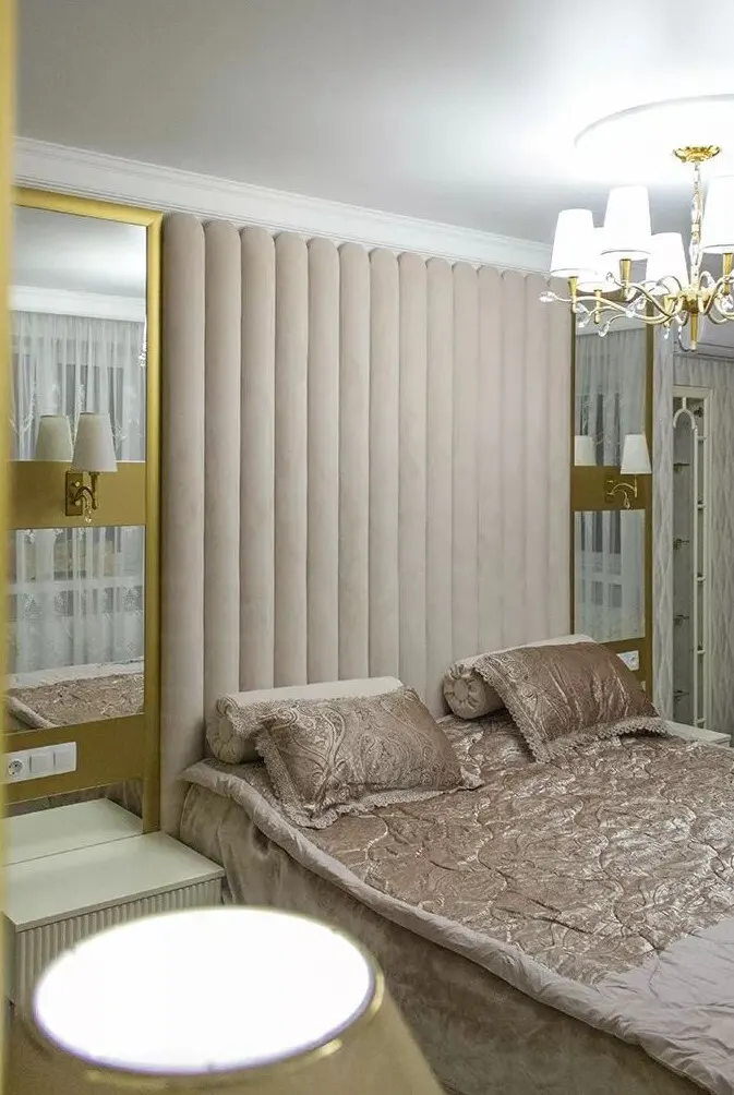 Классическая спальня с мягким изголовьем и золотыми акцентами